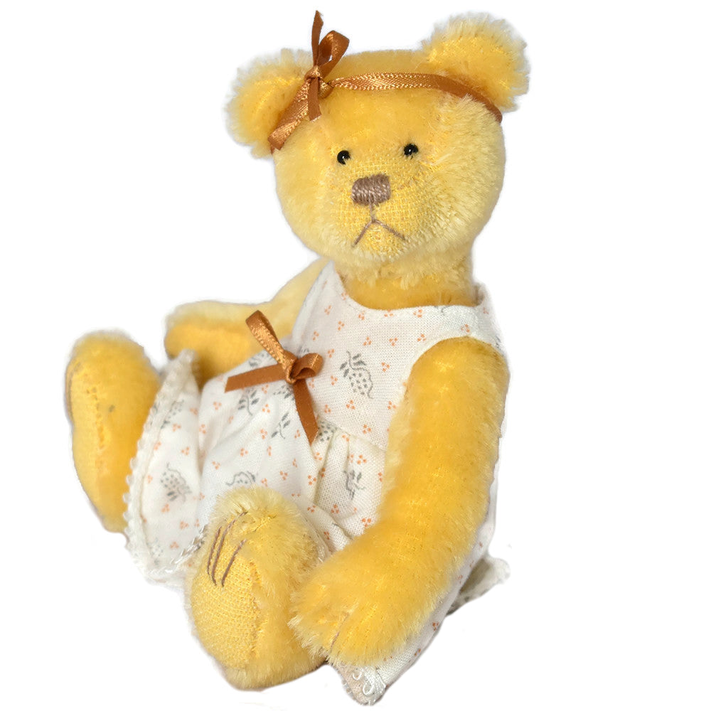 Bright yellow miniature teddy bear fully dressed